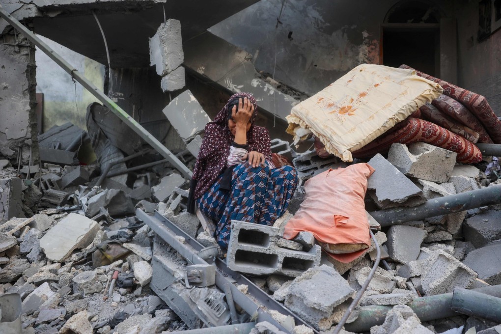 A woman cries while sitting on the rubble of her house, destroyed in an Israeli strike, in the Nuseirat refugee camp in central Gaza Strip. Photo: AFP