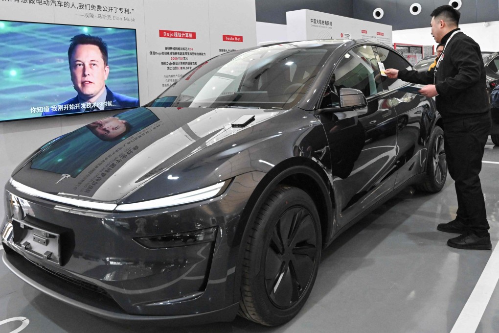 Customers check a Tesla Model Y at a delivery centre in Beijing