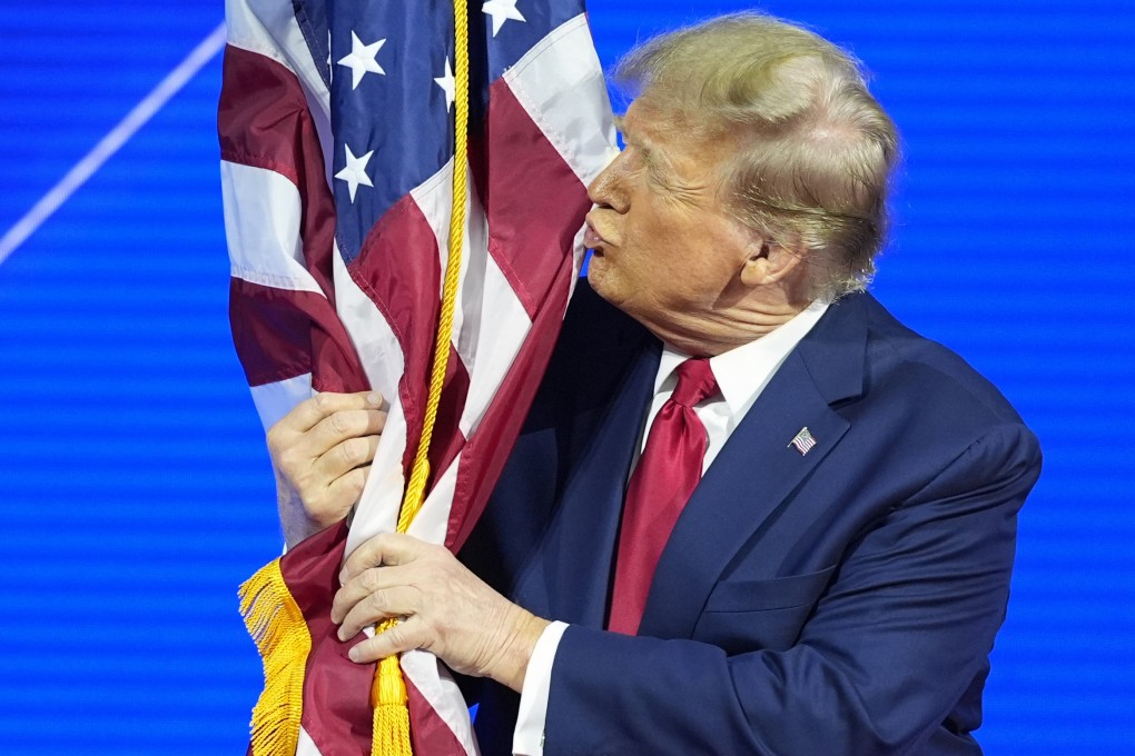 Donald Trump hugs and kisses the American flag as he speaks at the Conservative Political Action Conference on February 24, 2024. Photo: AP