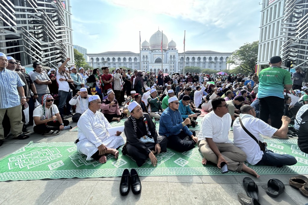 Members of the Malaysian Islamic Party wait outside the Palace of Justice in Putrajaya for a decision by the federal court. Photo: AP