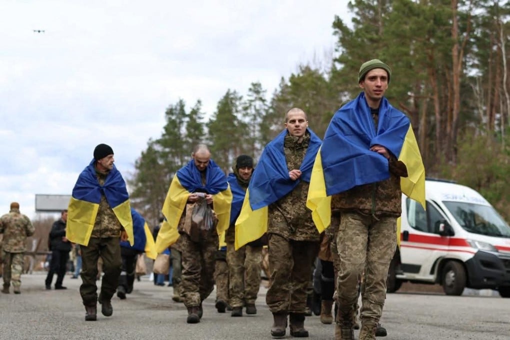 Some of the 175 Ukrainian prisoners of war wrapped with national flags, following an exchange with Russia. Photo: Volodymyr Zelensky via AFP