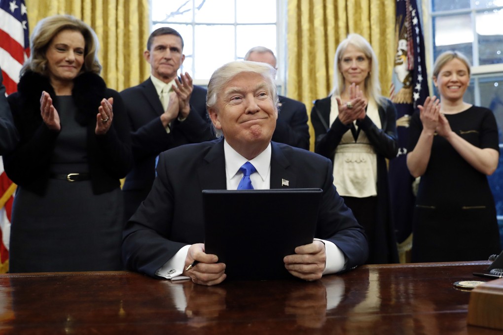 President Donald Trump smiles after signing three executive actions in the Oval Office on January 28, 2017, during his first term in office. Photo: AP