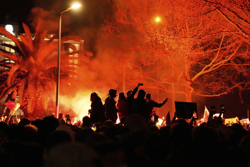 People light flares in Istanbul, Turkey on Thursday as they protest against the arrest of Istanbul’s Mayor Ekrem Imamoglu. Photo: AP