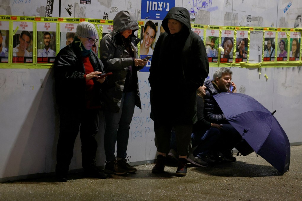 People protect themselves as they stand next to a wall in Jerusalem, Israel on Thursday as sirens goes off indicating a missile attack from Yemen. Photo: Reuters