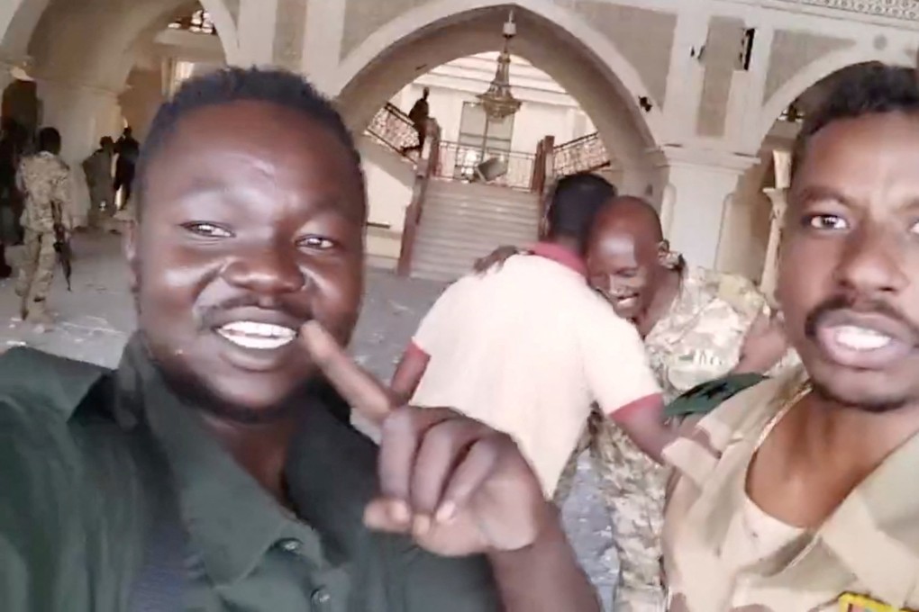 Sudanese army members film themselves inside the presidential palace in Khartoum on Friday, as the army says it has taken control of the building. Photo: Screenshot from social media video, via Reuters