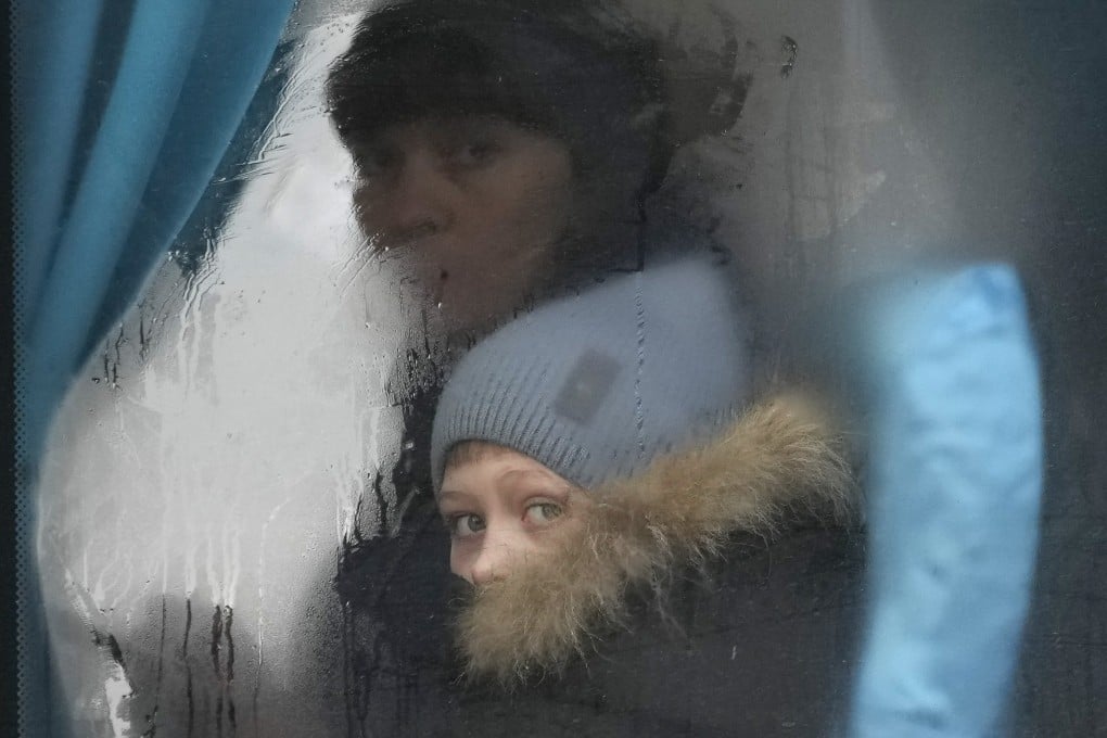 A woman and child peer out of a bus window as they leave eastern Ukraine on the day Russia invaded the country in February 2022. Photo: AFP
