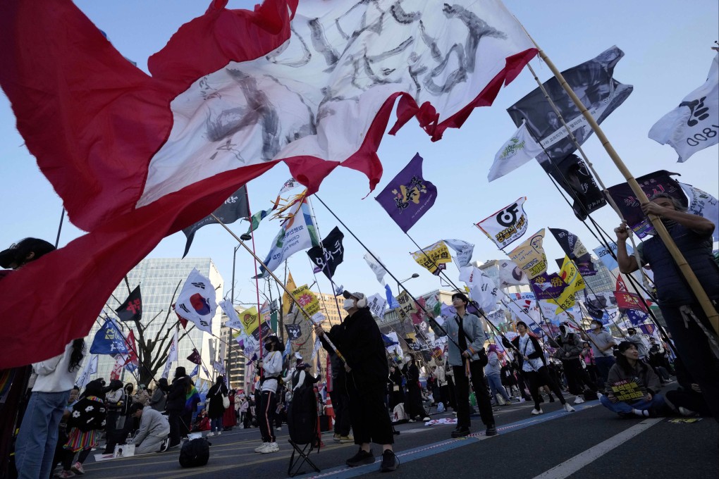 Protesters wave flags during a rally calling for impeached South Korean President Yoon Suk-yeol to step down, in Seoul on Saturday. Photo:AP