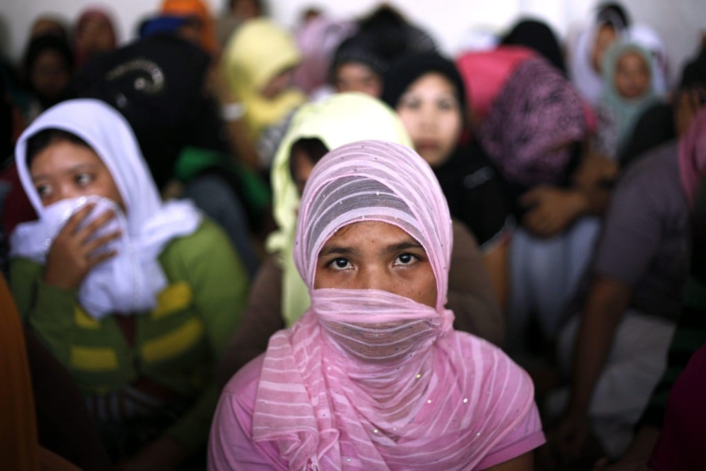 Indonesian migrant workers who were set to be sent to Saudi Arabia being inspected by the police at a shelter in Bekasi, West Java, Indonesia. Photo: EPA