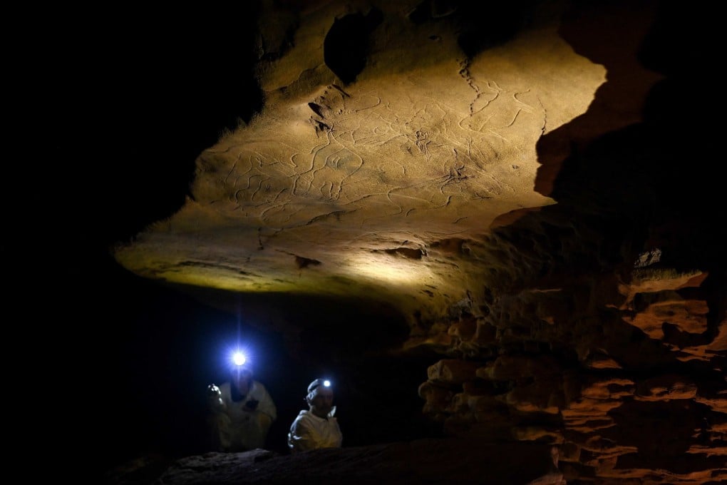 Reseearchers study the art in the Grotte de Cussac in southwest France. The cave is kept closed to protect the more than 1,000 ancient carvings within. The public can enjoy reproductions of the artworks at an exhibit in a nearby town. Photo: AFP
