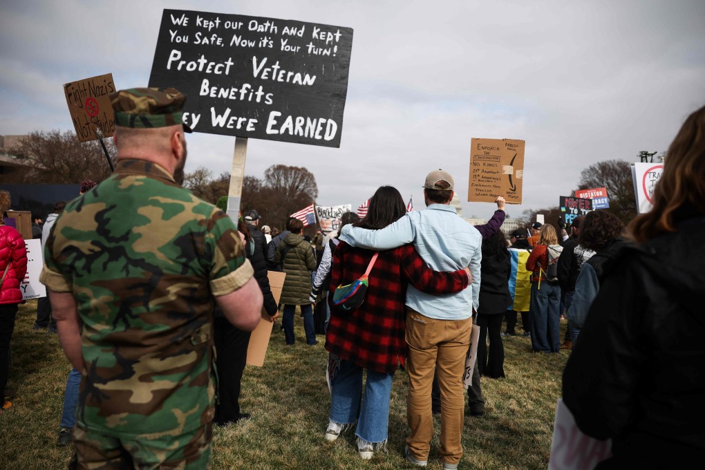 US Marine veteran, James Parker (left) holds a sign during a “Veterans March” at the National Mall on March 14 in Washington. Photo: AFP