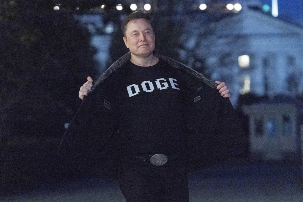 Elon Musk flashes his t-shirt that reads “DOGE” as he walks on South Lawn of the White House, in Washington, on March 9. Photo: AP