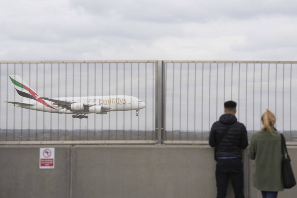 People watch an Emirates plane at Heathrow Airport in London on March 22. Photo: AP