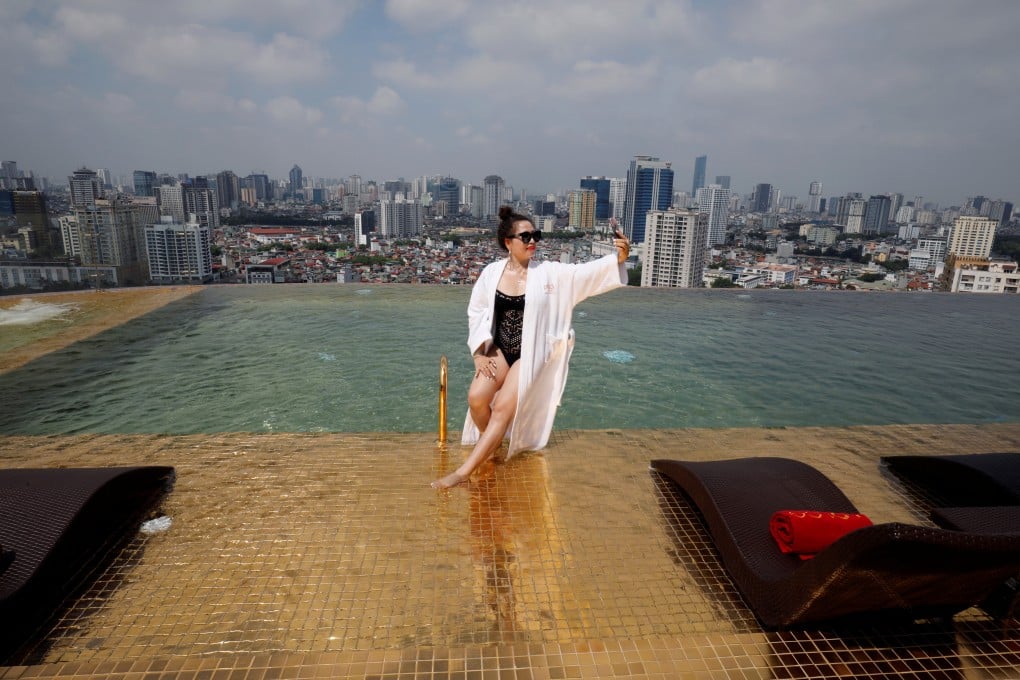 A woman poses for a photo at a gold plated infinity pool of a luxury hotel in Hanoi, Vietnam in 2020, after the government eases a nationwide Covid-19 lockdown. Photo: Reuters