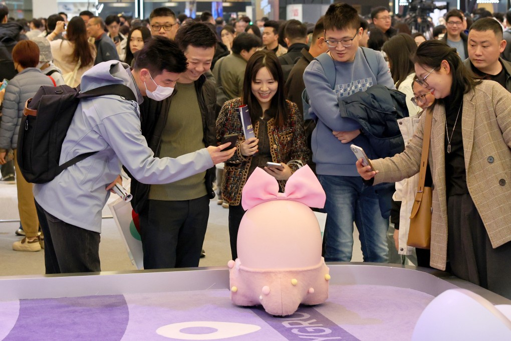 Visitors interact with TCL’s Ai Me companion robot at the China Home Appliances and Consumer Electronics Expo in Shanghai on March 20. Photo: Xinhua