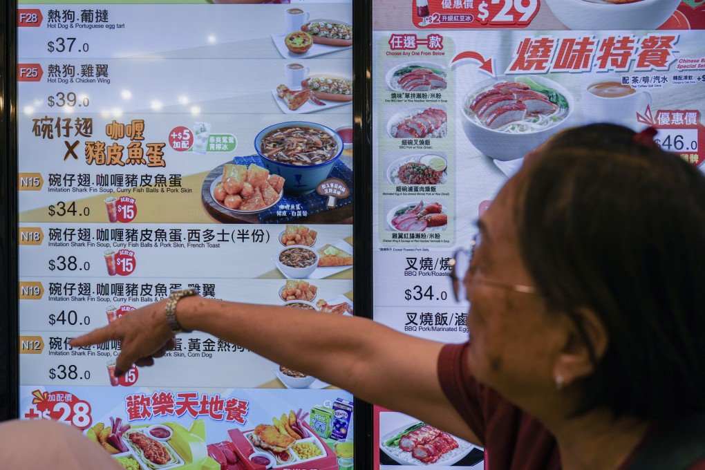 A customer selects dishes from the menu at a Café de Coral branch at Uptown Plaza in Tai Po, Hong Kong. Fast food chains rely on visuals to help their customers order - could more upmarket establishments also benefit? Photo: Eugene Lee