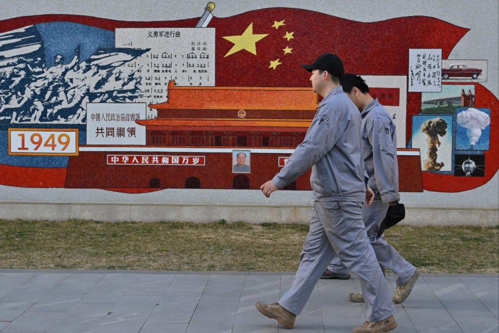 Workers walk past a mural depicting China’s history at the Zhongguancun No 1, an incubation platform for tech companies, in Beijing on March 19, 2025. Photo: AFP