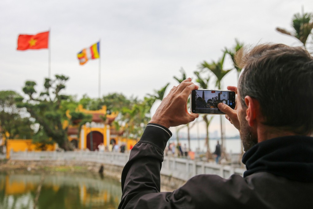 A tourist takes photos of a pagoda in Hanoi earlier this month. Vietnam is the regional leader in terms of its tourism recovery pace. Photo: EPA-EFE