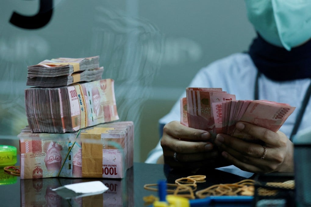 A teller counts rupiah banknotes at a money changer in Jakarta, Indonesia. Photo: Reuters