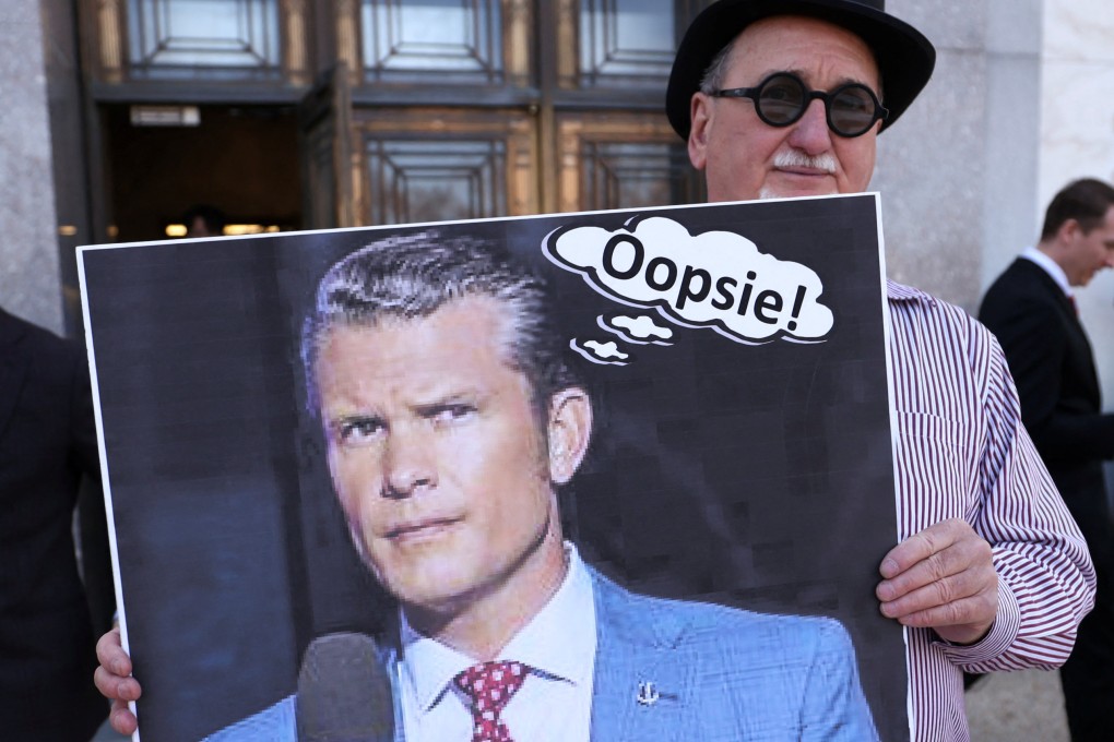 Demonstrator Gary Rush holds a placard depicting US Secretary of Defence Pete Hegseth as US intelligence chiefs appeared before a Senate Intelligence Committee hearing in Washington on Tuesday. Photo: Reuters