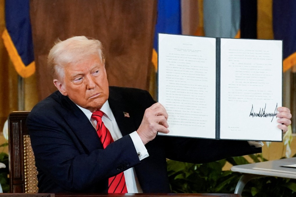 US President Donald Trump holds up a signed executive order. Photo: Reuters