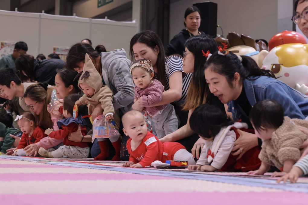 Parents position their babies before the start of a baby crawling contest during the “Children’s Book Fair & Super Parents & Kids Expo” on December 6 at the AsiaWorld-Expo, in Chek Lap Kok. Photo: Nora Tam