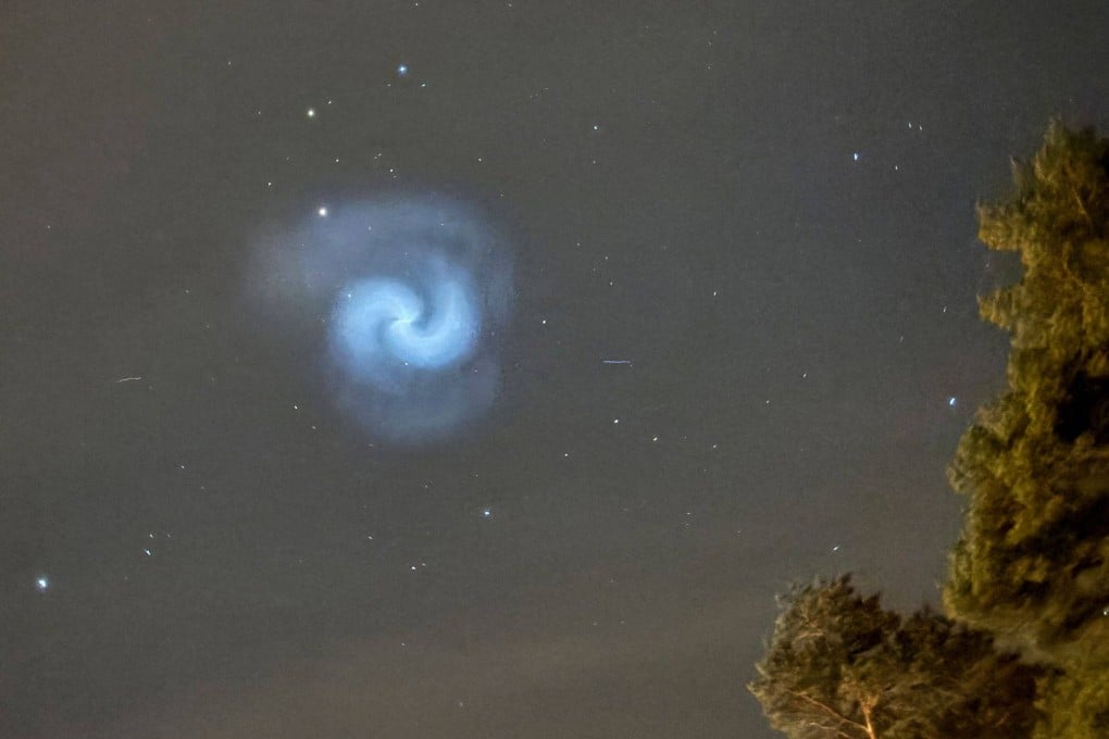 A picture taken in the countryside near Dalby-Viggeby, south of Uppsala, Sweden, on Monday shows a blue and white spiral in the night sky reportedly created by frozen fuel tumbling from a SpaceX rocket. Photo: Bertrand Ilhe via AFP