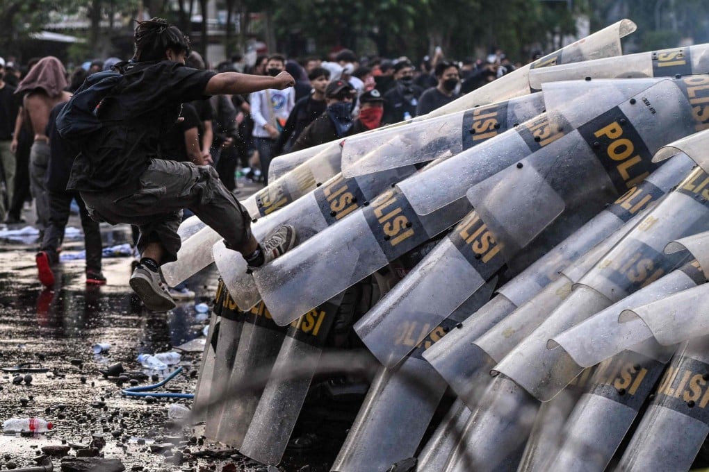 Anti-riot police put up their shields as students throw stones during a protest against a revision to the armed forces law in Surabaya on Tuesday. Photo: AFP