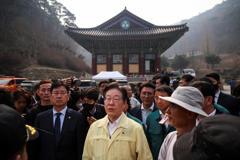 South Korea’s opposition chief Lee Jae-myung (centre) inspects a temple devastated by a wildfire in Uiseong on Thursday. Photo: Reuters