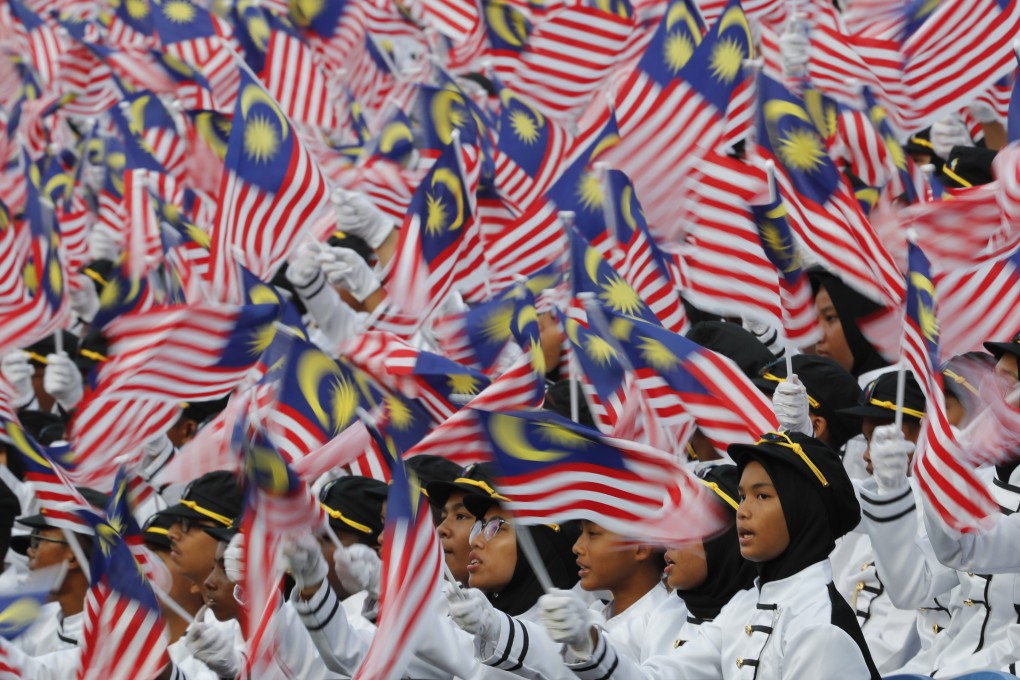 Students wave the Malaysian flag during National  Day celebrations. Photo: AP
