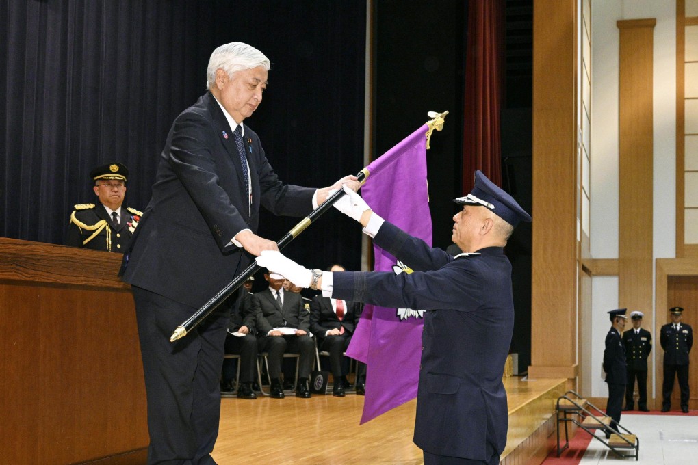 General Kenichiro Nagumo (right), who heads the Japan Self-Defence Forces’ newly created Joint Operations Command, receives the commander’s flag from Defence Minister Gen Nakatani in Tokyo on Monday. Photo: Kyodo
