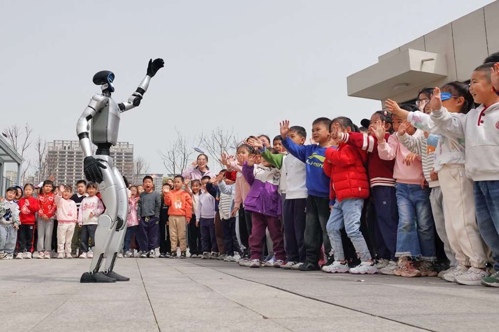 A Unitree G1 humanoid robot waves to children at a kindergarten in Yantai, Shandong province. Photo: CFOTO/Future Publishing via Getty Images