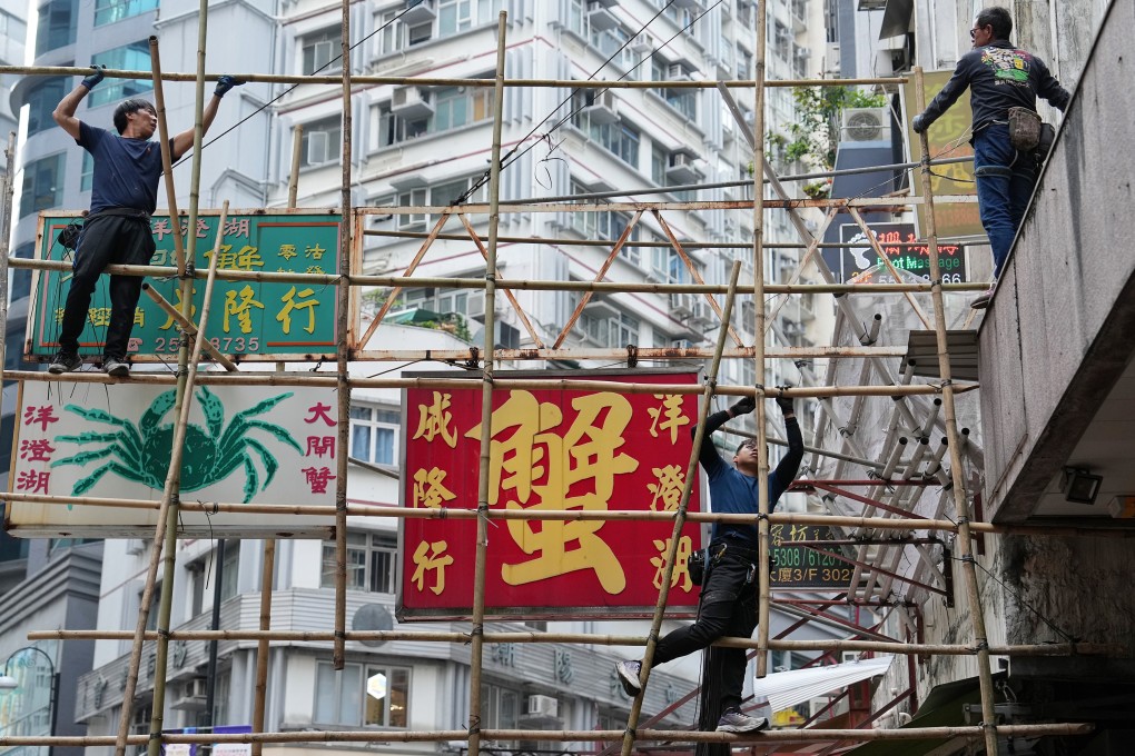 Workers set up a bamboo scaffold to repair billboards in Sheung Wan in 2024. Photo: Elson Li