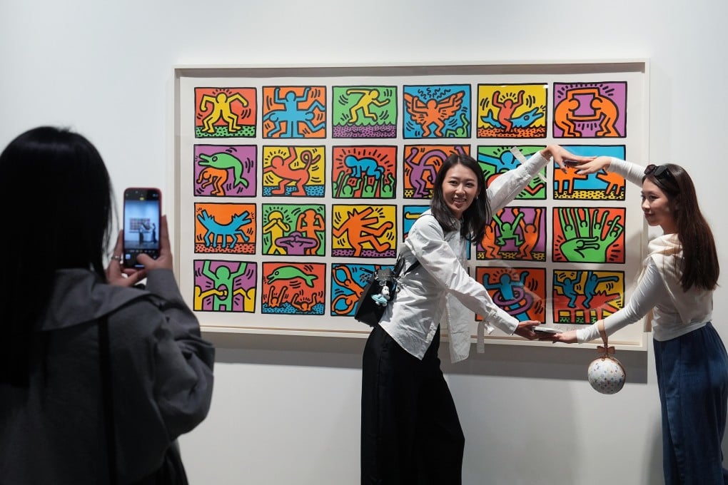 Visitors take pictures with an artwork by Keith Haring at Art Basel Hong Kong.Photo: Elson Li