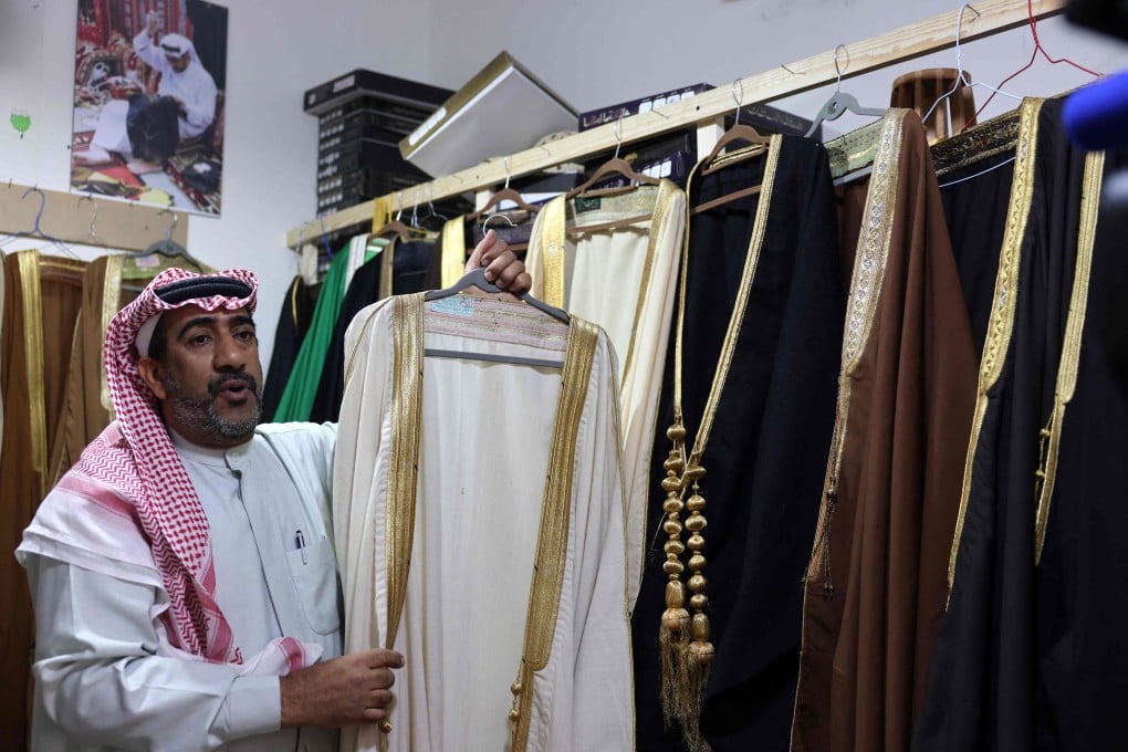 Saudi tailor Habib Mohammed shows hand-woven robes at his workshop in the city of Hofuf, where he teaches his endangered robe-weaving craft to young people. Photo: AFP