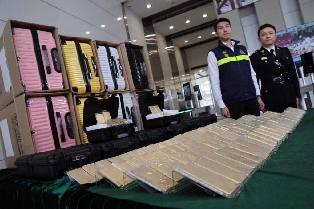 Customs officers Anthony Tang (left) and Ip Kin-sang display the suspected gold bars found in suitcases that were part of plane cargo bound for Japan. Photo: Jelly Tse
