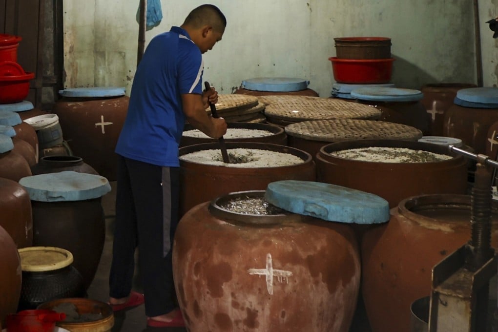 A villager makes fish sauce in his home in Nam O, Da Nang, Vietnam. Climate change is affecting the supply of anchovies on which the traditional trade depends. Photo: AP