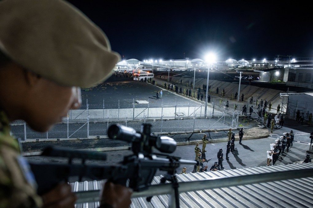 Salvadoran police officers escort alleged members of the Tren de Aragua gang, recently deported by the US government to be imprisoned in the Terrorism Confinement Centre prison as part of an agreement with the Salvadoran government, in Tecoluca, El Salvador, on March 16. Photo: Secretaria de Prensa de la Presidencia/Retuers