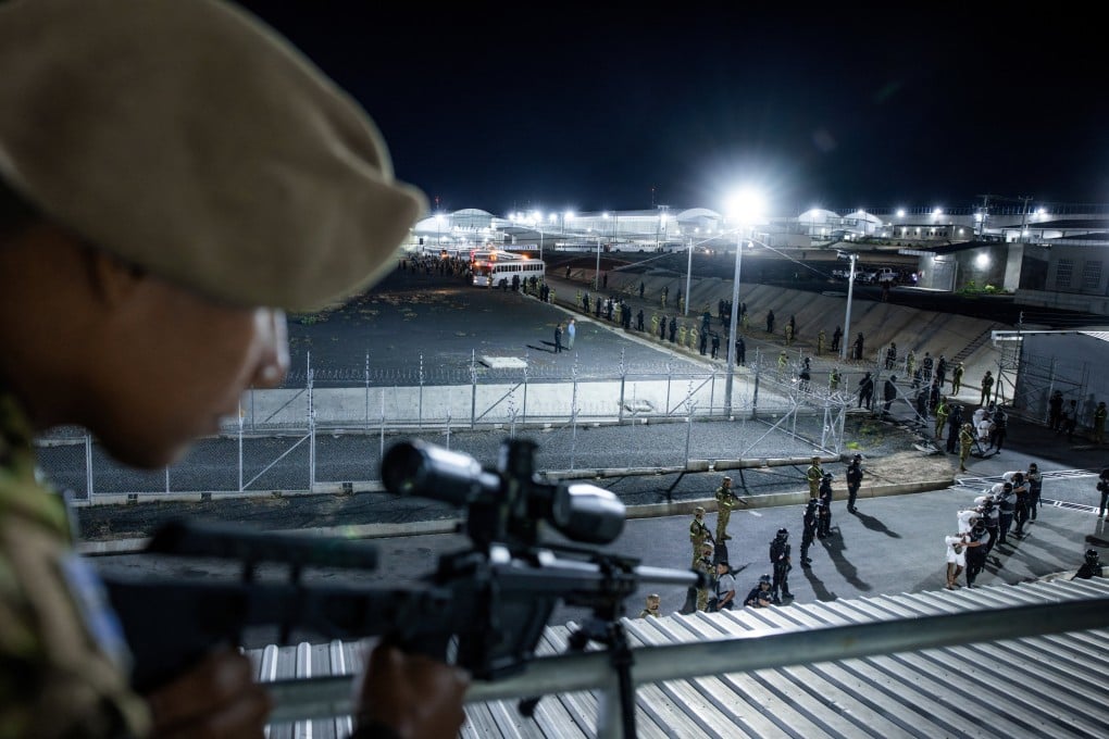 Salvadoran police officers escort alleged members of the Tren de Aragua gang, recently deported by the US government to be imprisoned in the Terrorism Confinement Centre prison as part of an agreement with the Salvadoran government, in Tecoluca, El Salvador, on March 16. Photo: Secretaria de Prensa de la Presidencia/Retuers