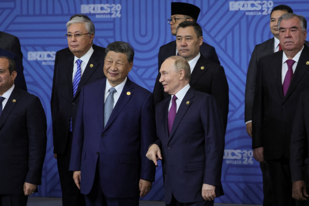 Russian President Vladimir Putin speaks with Chinese President Xi Jinping as other participants in the outreach/BRICS Plus format meeting pose for a photo during the BRICS summit in Kazan, Russia on October 24, 2024. Photo: Maxim Shipenkov