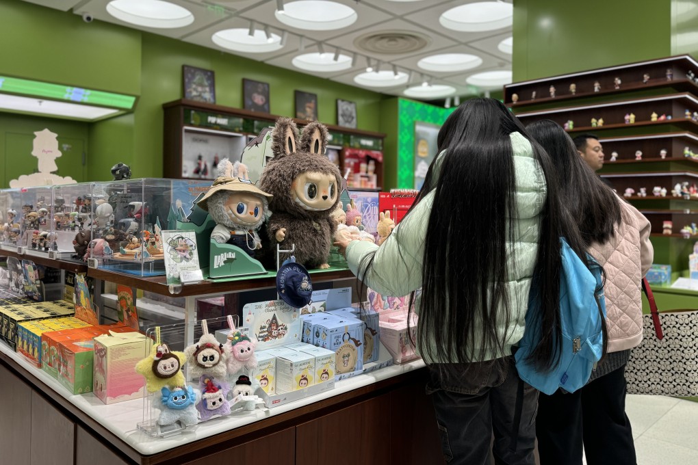 professional photograph of Labubu collectible figures displayed at POP MART store with customers browsing