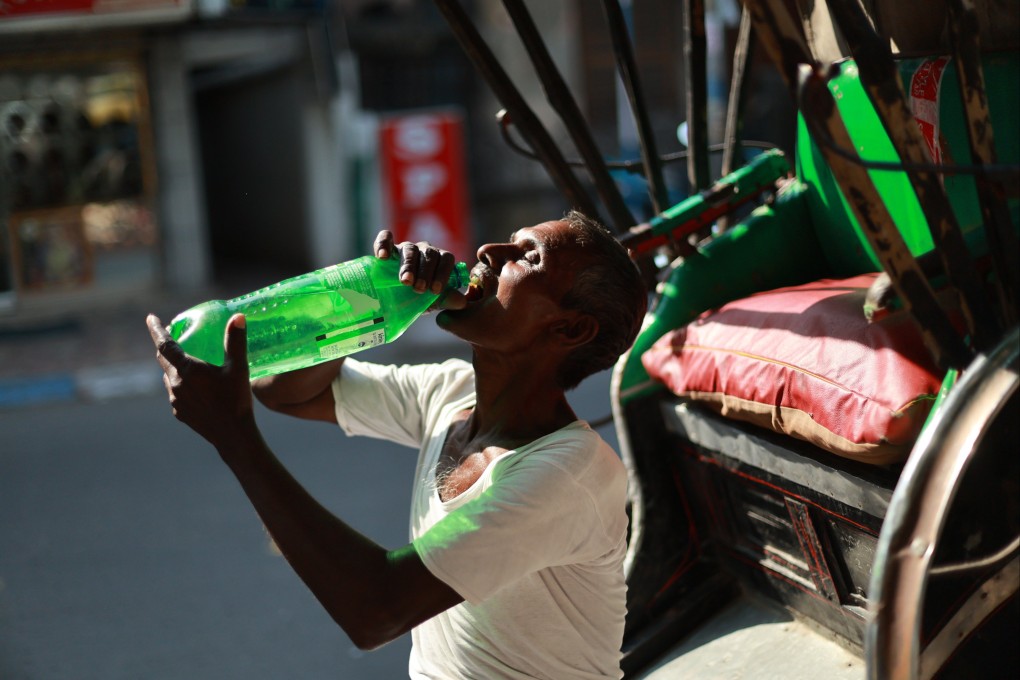 An Indian rickshaw puller drinks from a plastic bottle during a hot afternoon in Kolkata, India, on March 27. Photo: EPA-EFE