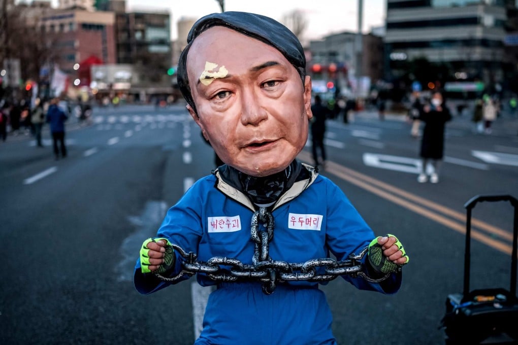 A protester wearing a mask of Yoon Suk-yeol performs on a street in Seoul during a demonstration against South Korea’s impeached president on Saturday. Photo: AFP