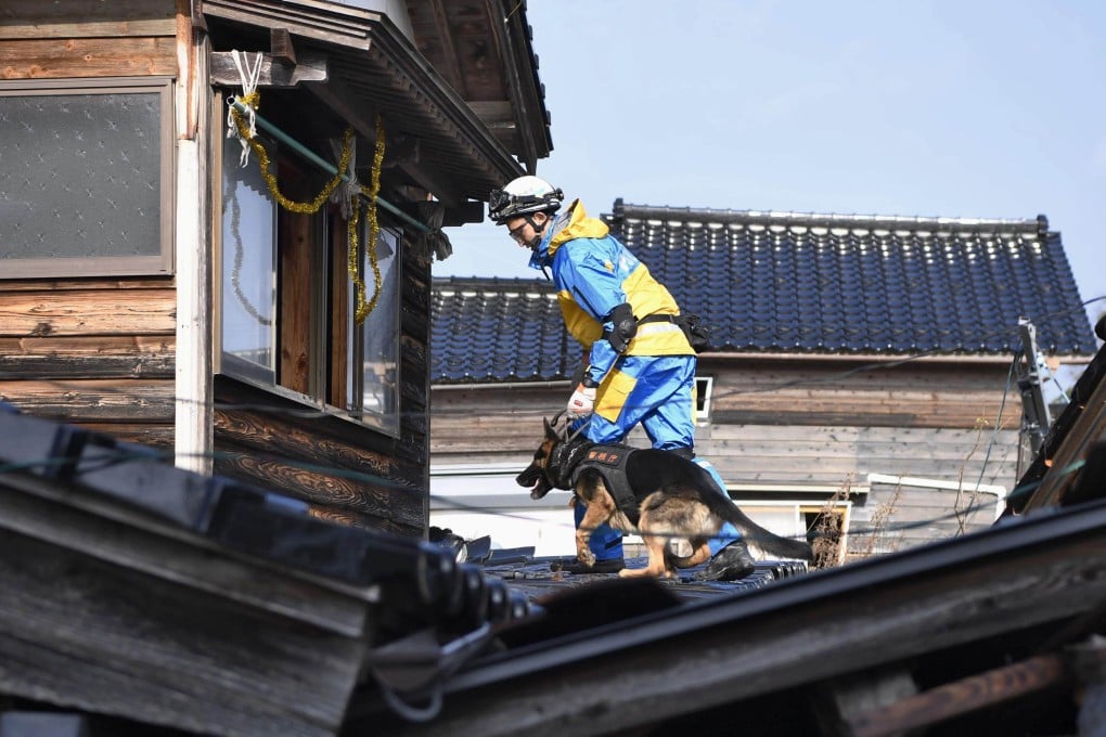 A police officer and a rescue dog search for survivors after a earthquake hit the Noto Peninsula on January 1, 2024. Photo: Kyodo