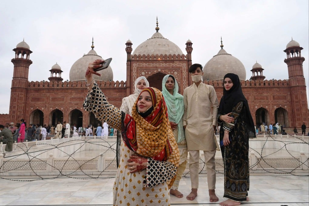 A woman takes a selfie with her friends after offering prayers at the Badshahi Mosque in Lahore, Pakistan. About two-thirds of the population are under 30, and many are eager to adopt new technology. Photo: AFP