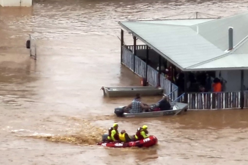 Rescue workers taking residents from a house on a flooded street in the town of Adavale in southwest Queensland. Photo: Queensland fire Department/AFP