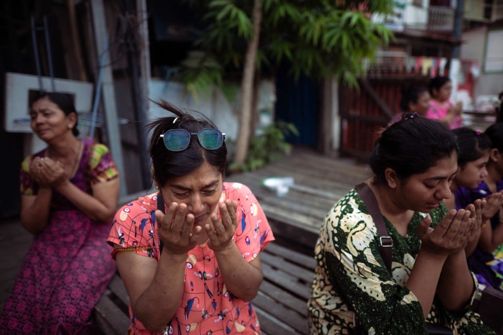 A Muslim woman cries while offering morning prayers on a road near destroyed mosques in Mandalay on March 31, three days after the deadly Myanmar earthquake. Photo: AFP