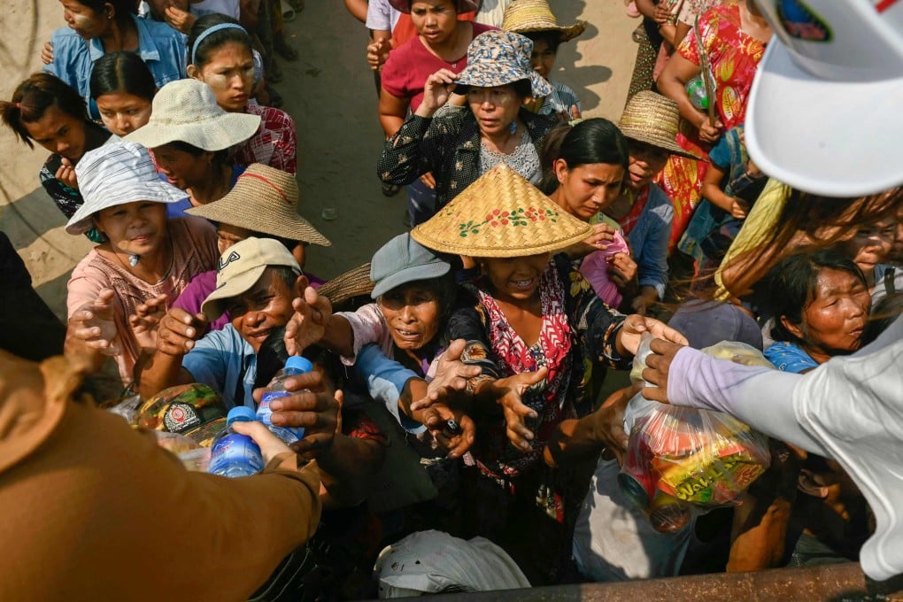 People in Sagaing, the epicentre of the March 28 earthquake, reach out for food aid being distributed on Thursday. Photo: AFP