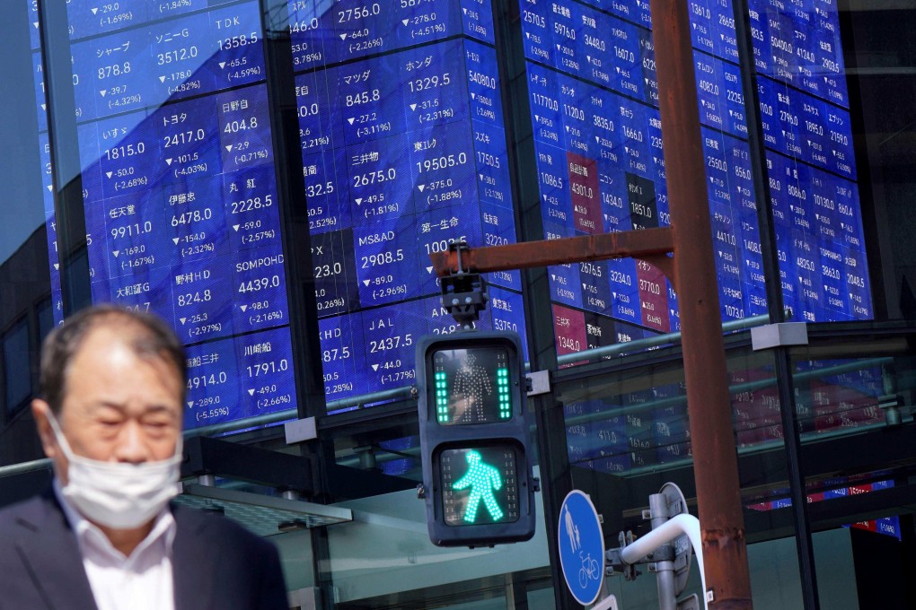 A man walks past an electronic board showing the Nikkei 225 Index in Tokyo on April 4, 2025. Photo: AFP