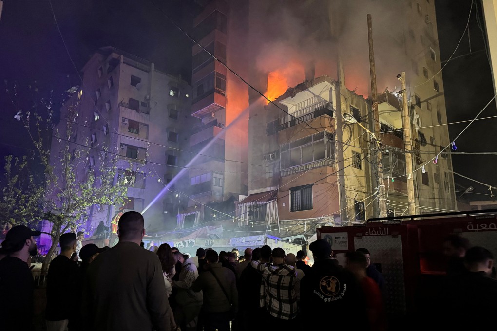 Firefighters try to put out a fire at a building following an Israeli strike, in which the Israeli military said it killed Hamas commander Hassan Farhat, in Sidon, Lebanon on Friday. Photo: Reuters
