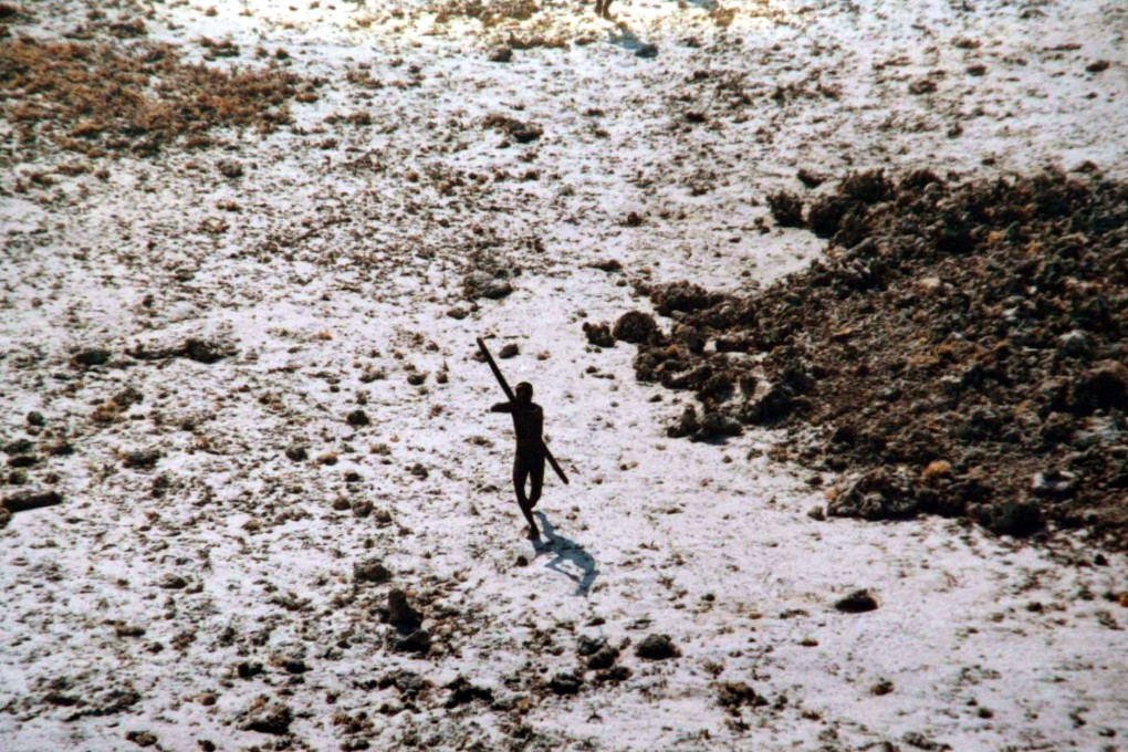 A Sentinel tribal man aims with his bow and arrow at an Indian Coast Guard helicopter as it flies over their island for survey in Indias Andaman and Nicobar archipelago in 2004. Photo: AP/Indian Coast Guard